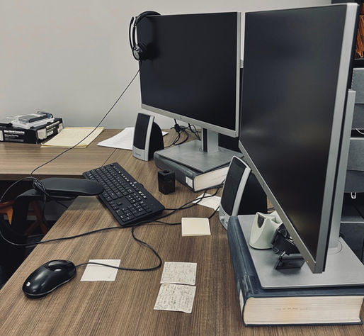 Picture of two computer monitors on a desk with various equipment.